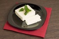 Sliced cheese on black dish with napkin Royalty Free Stock Photo