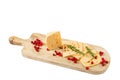 Sliced cheese, cranberries and rosemary on a wooden cutting board. Isolate on white background