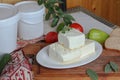 Sliced cheese with herbs and olive on a wooden background