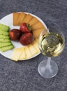Sliced cheese on a plate with a glass of wine. Royalty Free Stock Photo