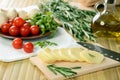 Sliced cheese, tomatoes and herbs on a kitchen table