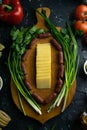 Sliced cheese on a wooden board, around the ham, green onions, tomato, souce, olives, lemon, spice, dill Royalty Free Stock Photo