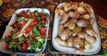 Sliced chicken and young potatoes baked in the oven and a salad of fresh small tomatoes with green salad Royalty Free Stock Photo