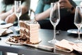 Sliced ??chocolate themed cake and champagne glasses on the table with blurred people in the background. Royalty Free Stock Photo