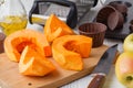 Sliced and chopped pumpkin pieces. Pumpkin chunks on wooden background. Fresh and ripe pumpkin detail vegetable and halloween