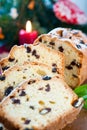 Sliced christmas fruitcake with raisins on festive background