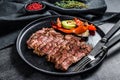 Sliced Chuck eye roll on a plate with a side dish of vegetables. Black background. Top view Royalty Free Stock Photo