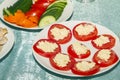 Sliced in circle tomatoes with cottage cheese or cheese on white plate. Cold snack on buffet table. Side view and copy space