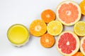 Sliced citrus on a white background with a glass of fresh juice. Grapefruit, lemon, tangerine. Royalty Free Stock Photo