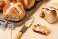 Sliced cross bun and knife with butter Royalty Free Stock Photo