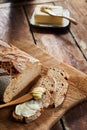 Sliced crusty loaf of fresh rye bread with butter Royalty Free Stock Photo