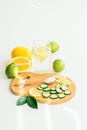 Sliced cucumber and orange , a spoon with salt and a glass with water and lemon