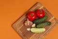 Sliced cucumber, tomatoes and garlic on wooden cutting board. Tomatoes with green ponytails. Healthy food. Copy space Royalty Free Stock Photo