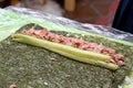 Sliced cucumbers and stew, homemade sushi are laid out on a nori sheet