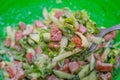 Sliced cucumbers, tomatoes, onions, mayonnaise. Ingredients for the salad. Salad on spoon. Blurred background Royalty Free Stock Photo