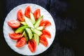 Sliced cucumbers and tomatoes and vegetables on a plate