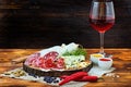 Sliced cured sausage with spices and a glass of red wine. Royalty Free Stock Photo