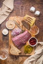 Sliced Deli Pastrami on wooden board, flat lay