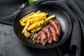 Sliced Denver steak with French fries, marbled meat. Black background. Top view Royalty Free Stock Photo