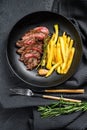 Sliced Denver steak with French fries, marbled meat. Black background. Top view Royalty Free Stock Photo