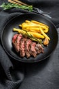 Sliced Denver steak with French fries, marbled meat. Black background. Top view Royalty Free Stock Photo