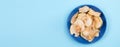 Sliced, dried apples in a plate isolated on blue background. Homemade organic apple. Banner