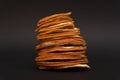 Sliced dried dehydrated oranges one on other, in a stack, at black background Royalty Free Stock Photo