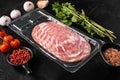 Sliced dry cured sausage in vacuum pack, on black dark stone table background Royalty Free Stock Photo