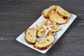 Sliced Easter bread and eggs in white plate on grey wooden board. Royalty Free Stock Photo