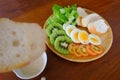 Sliced egg salad served with vegetable, kiwi, tomato, crispy bread, separated sesame dressing, and bread as foreground Royalty Free Stock Photo