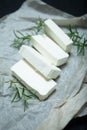 Sliced feta cheese with rosemary on the table