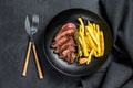 Sliced Flat Iron steak with French fries, marbled meat. Black background. Top view Royalty Free Stock Photo