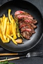 Sliced Flat Iron steak with French fries, marbled meat. Black background. Top view Royalty Free Stock Photo