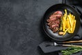 Sliced Flat Iron steak with French fries, marbled meat. Black background. Top view. Copy space Royalty Free Stock Photo