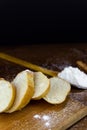Sliced French baguette on a wooden board  cinnamon sticks and a large spoonful  heavily floured on a wooden table with Royalty Free Stock Photo