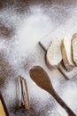 Sliced French baguette on a wooden board  cinnamon sticks and a trail of a large spoon  heavily floured on a wooden table Royalty Free Stock Photo