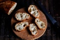Sliced French baguette on a wooden board on a dark background. Bread with big holes. Preparing for bruschetta Royalty Free Stock Photo