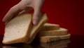 Sliced fresh bread lies on the black table. Stock footage. Close up of hand taking one of the slices of baked white cut Royalty Free Stock Photo