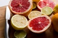 Sliced fresh citrus lemons, limes, grapefruits on a wooden board with a metal knife, side view Royalty Free Stock Photo