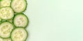 Sliced fresh cucumber on light green background. Close up, top view. With copy space Royalty Free Stock Photo