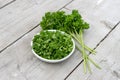 Bunch and sliced ??fresh curly parsley on a light wooden background