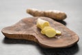 Sliced fresh ginger root on olive wood board
