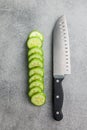 Sliced fresh green cucumber and knife on kitchen table. Top view Royalty Free Stock Photo