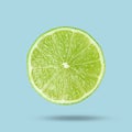 Sliced fresh juicy lime in air on light blue background. Citrus fruit Royalty Free Stock Photo