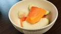 sliced ??fresh papaya Bite-sized pieces of guava in a white bowl ready to serve. Close-up photo.