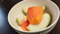 sliced ??fresh papaya Bite-sized pieces of guava in a white bowl ready to serve. Close-up photo.