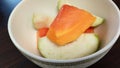 sliced ??fresh papaya Bite-sized pieces of guava in a white bowl ready to serve. Close-up photo.