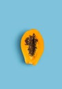 Sliced fresh papaya on blue background. Creative minimalizm