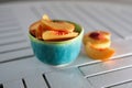 Sliced fresh yellow peach in bright blue ceramic bowl on white kitchen table Royalty Free Stock Photo