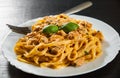 Sliced fried chicken breast meat in a creamy sauce with bavette pasta in a plate